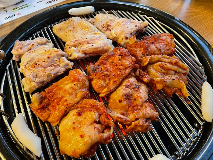 숯불 위에서 노릇하게 익어가고 있는 닭갈비 조각들