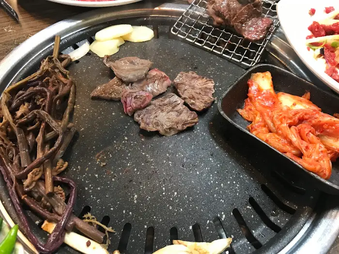 불판 위에서 구워지는 한우와 곁들임