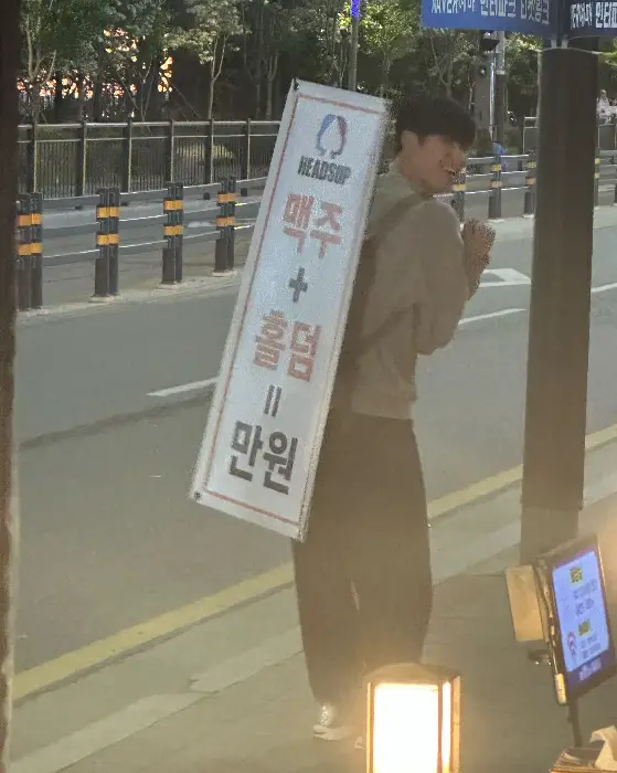 맥주와 하이볼을 홍보하는 입간판을 들고 있는 직원