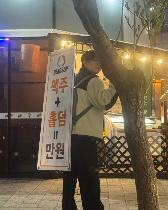 입간판을 들고 있는 직원의 뒷모습
