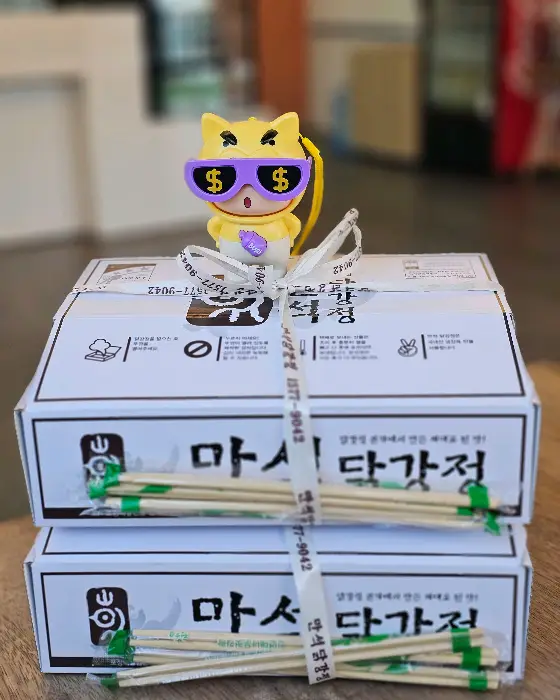 만석닭강정 박스와 젓가락이 함께 담긴 사진