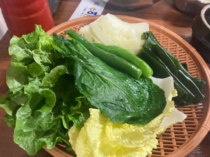 신선한 쌈 채소와 고추, 깻잎 등이 담긴 바구니
