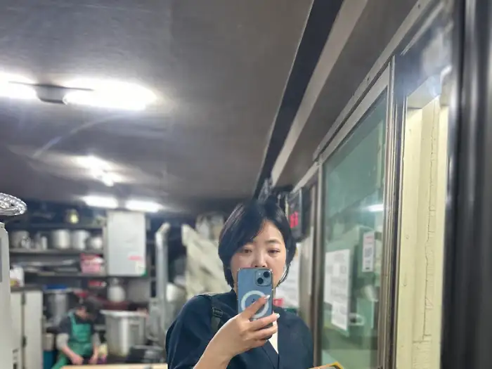 식당 내부에서 휴대폰으로 셀카를 찍는 모습