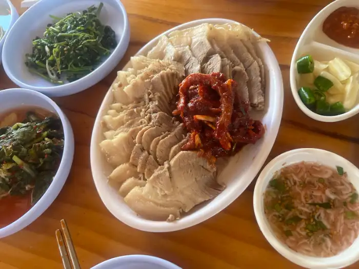 수육 한 접시와 다양한 반찬들
