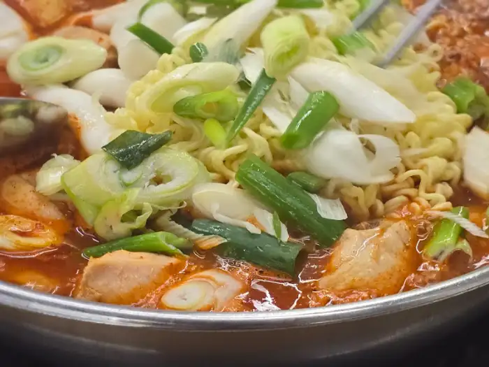 닭볶음탕 냄비의 클로즈업, 닭고기와 채소, 라면사리가 가득