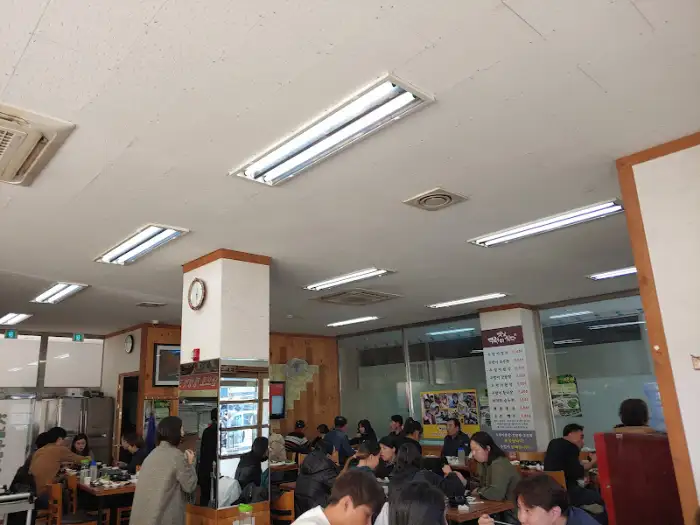 식당 내부 모습. 다수의 손님이 식사 중이며, 따뜻한 조명이 내부를 비춘다.