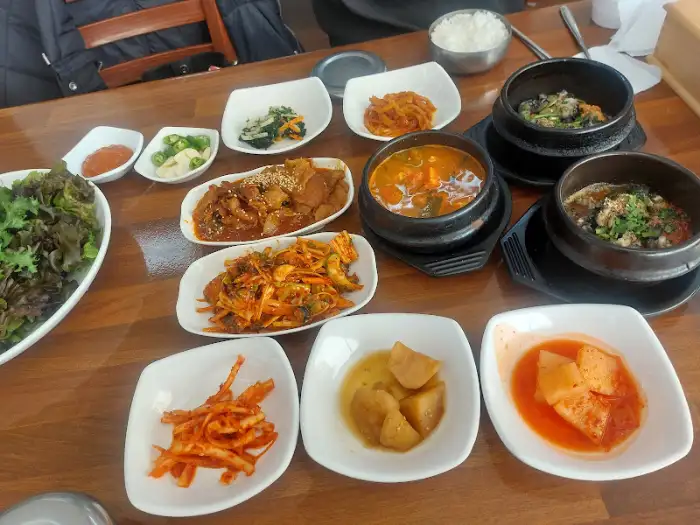 우렁이 정식의 푸짐한 상차림. 다양한 반찬과 메인 요리가 조화롭게 담겨 있다.
