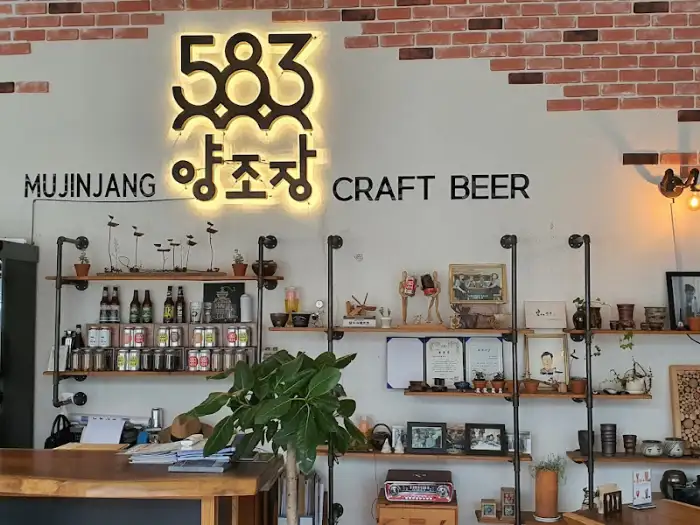 583 양조장 벽면, '583 양조장 CRAFT BEER' 간판과 다양한 장식품이 진열된 선반들이 보입니다.
