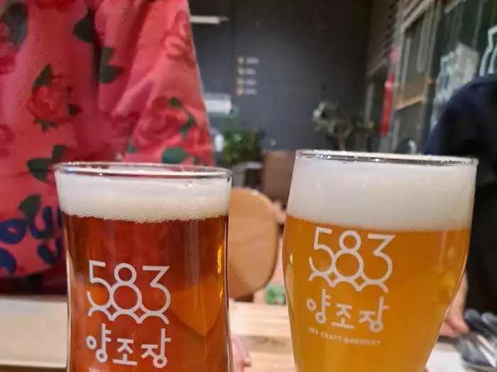 색이 다른 두 잔의 수제 맥주가 테이블 위에 놓여 있습니다.