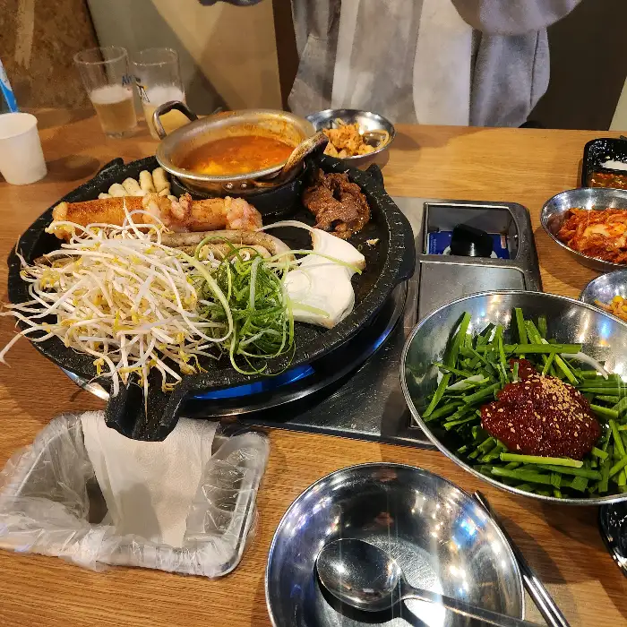 푸짐하게 차려진 곱창구이와 곁들임 메뉴, 순두부찌개
