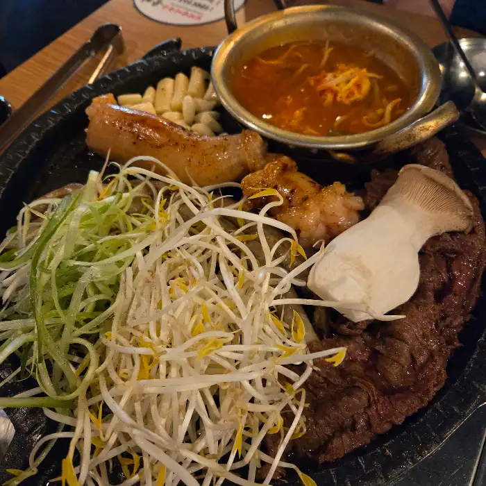 잘 익은 곱창과 큼직한 버섯, 그리고 곁들임 채소들이 조화롭게 담겨 있다.