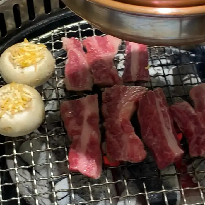 숯불 위에서 맛있게 익어가는 갈비살과 버섯