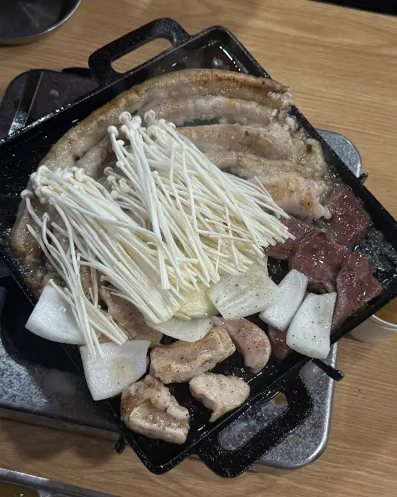 모듬 곱창에 버섯, 양파 등 다양한 재료가 함께 구워지고 있는 모습