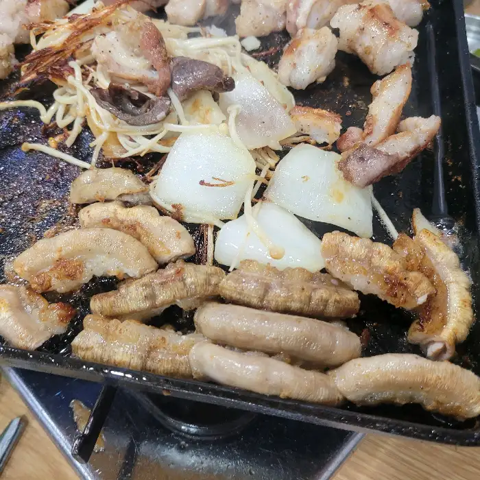 한쪽에서는 사장님이 직접 곱창을 구워주고, 다른 쪽에는 손님들이 식사 중인 모습