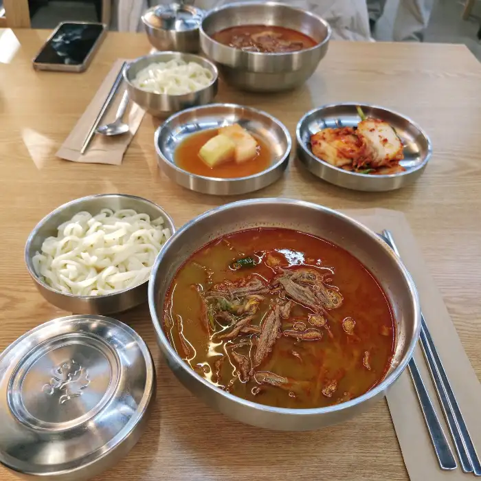 테이블에 차려진 육개장, 육전, 국수, 만두 등 다양한 메뉴