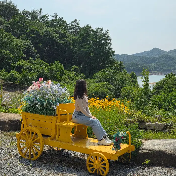 꽃으로 장식된 노란색 마차 모양의 포토존