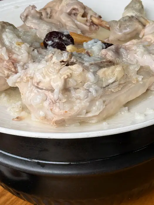 누룽지백숙 전체 모습, 닭고기와 누룽지죽이 함께 담겨있다.
