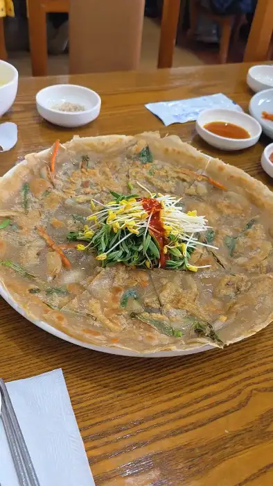 메밀전 모습, 얇게 부쳐져 있고 가운데에는 콩나물이 올려져 있다.