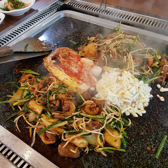 한쪽에는 볶음 요리가 다른 한쪽에는 밥이 담겨 있다.