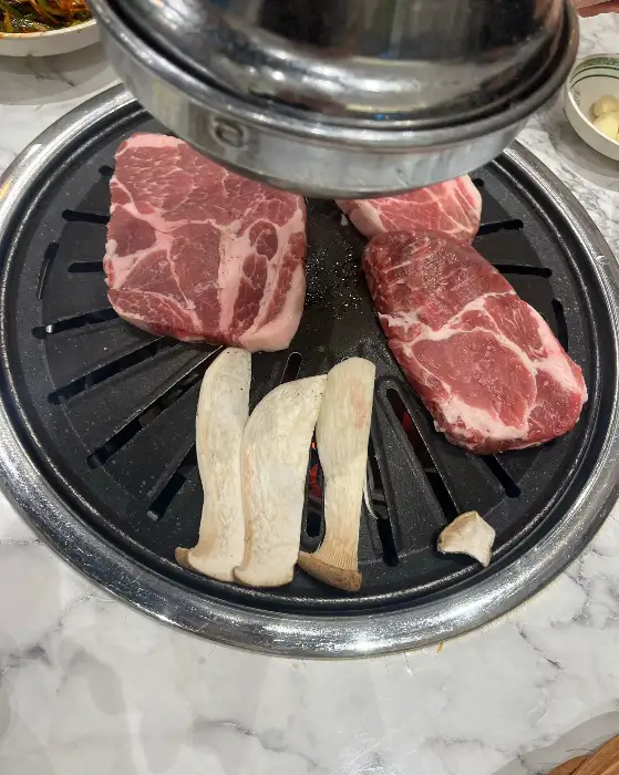 불판 위에서 지글지글 익어가는 삼겹살과 목살