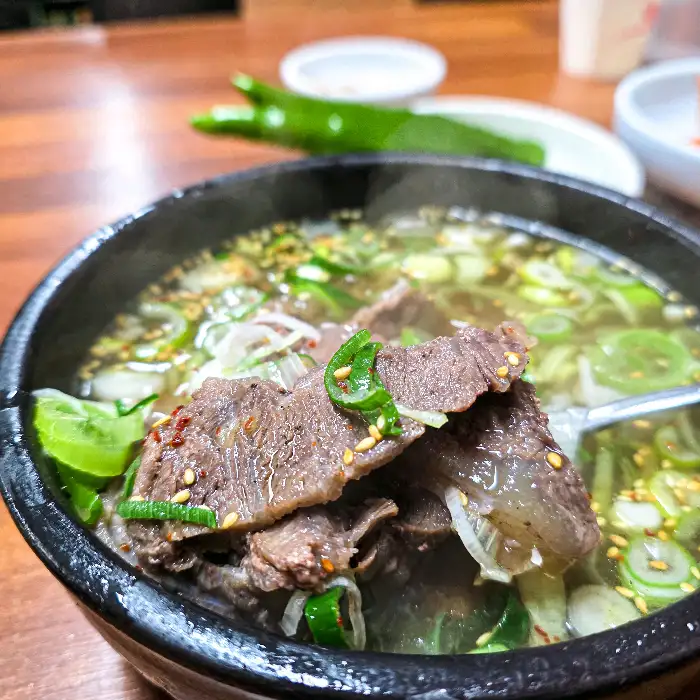 육회가 담긴 접시와 곰탕의 일부 모습