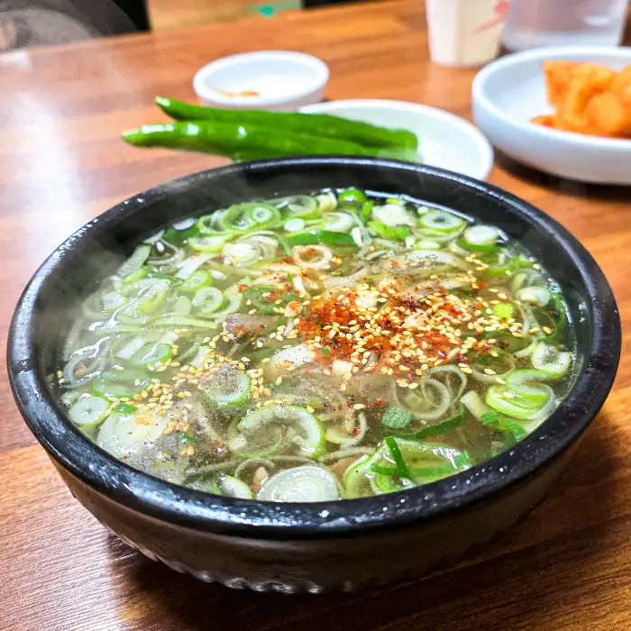 김이 올라오는 곰탕 그릇의 클로즈업 사진