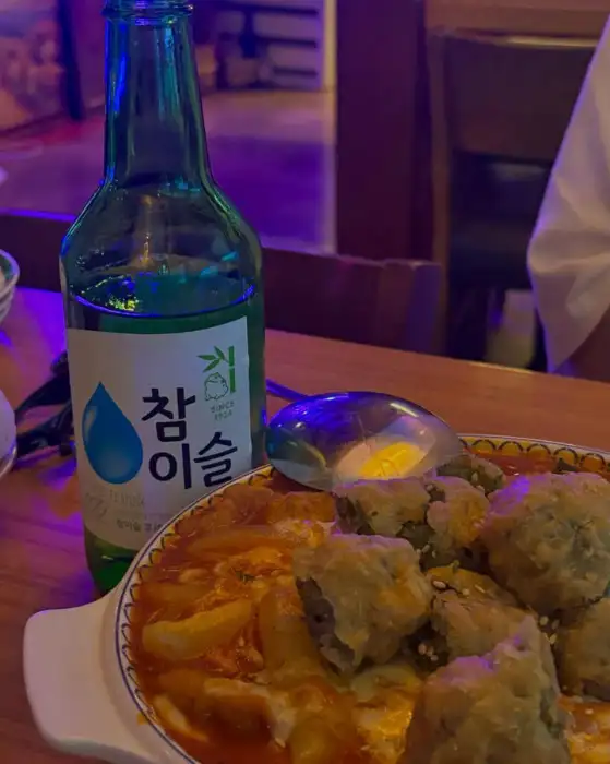 테이블 위에 놓인 떡볶이 그라탕과 소주