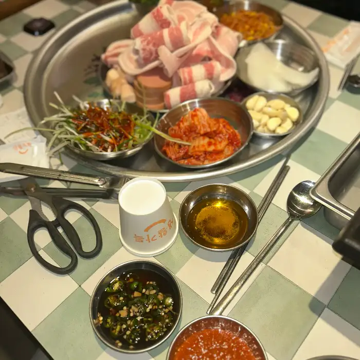 밑반찬으로 나온 김치, 마늘, 쌈 채소 등