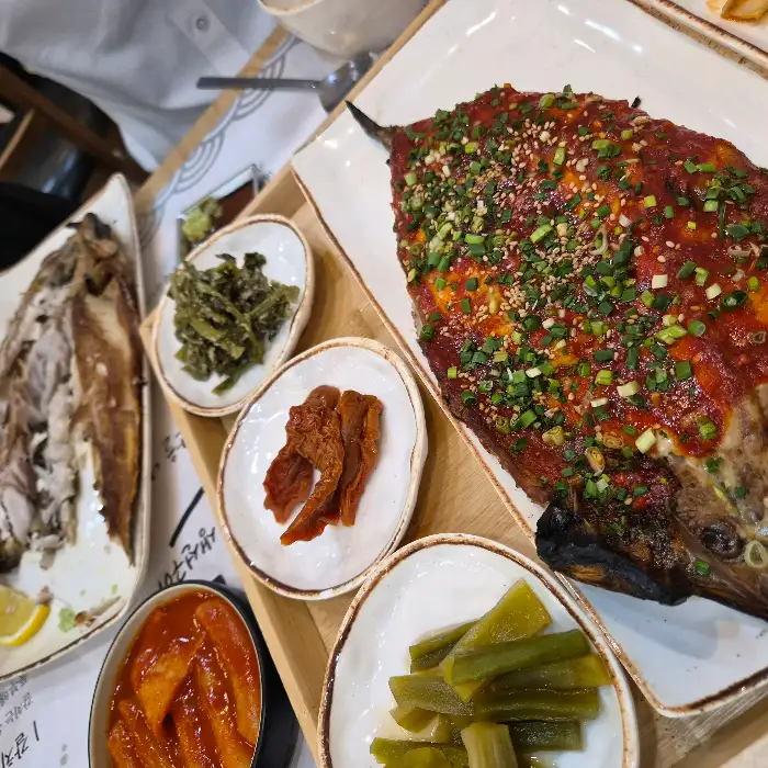 푸짐한 생선구이와 곁들여 나온 떡볶이, 가지튀김, 잡채 등 밑반찬