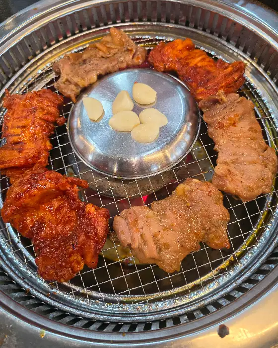 잘 익은 닭갈비 조각들이 숯불 위에 놓여있는 모습