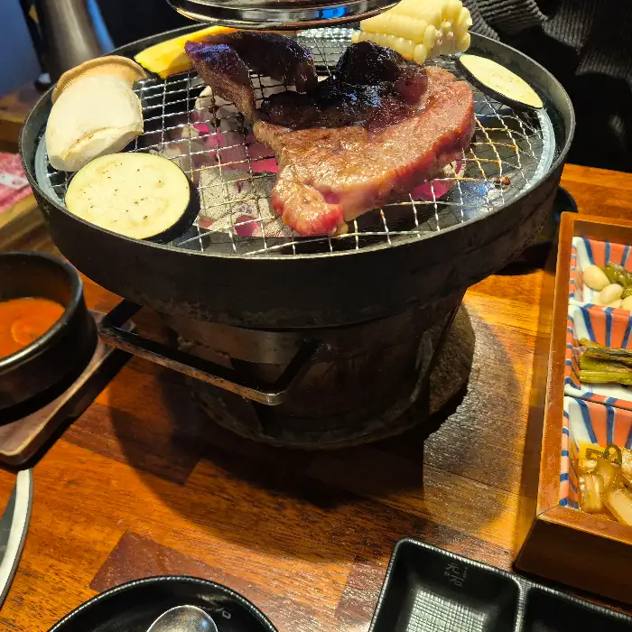 테이블 위에서 맛있게 구워지고 있는 소고기와 야채