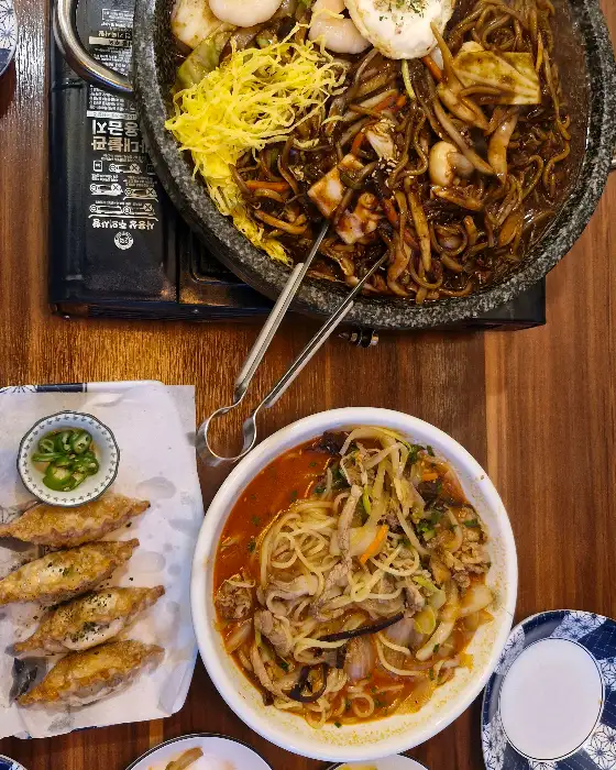 돌판 위에 짜장면과 곁들임 메뉴들이 함께 나온 모습. 전체적으로 풍성한 양이 인상적이다.