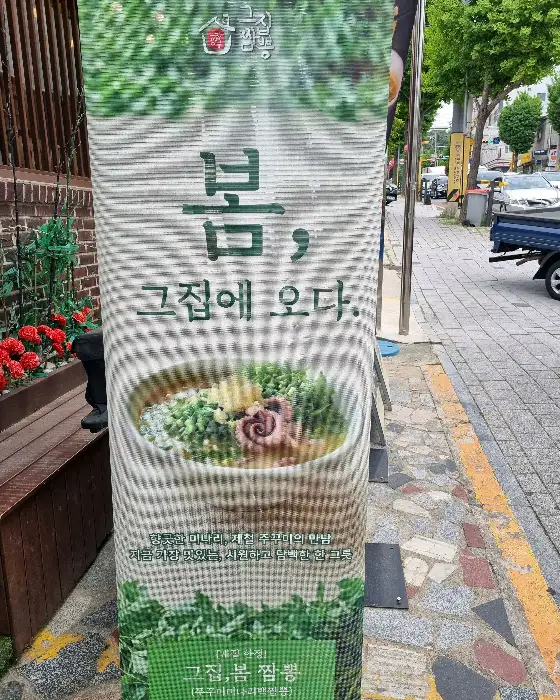 봄, 그집에 오다 라는 문구가 적힌 현수막. 짬뽕 메뉴 이미지가 함께 있다.