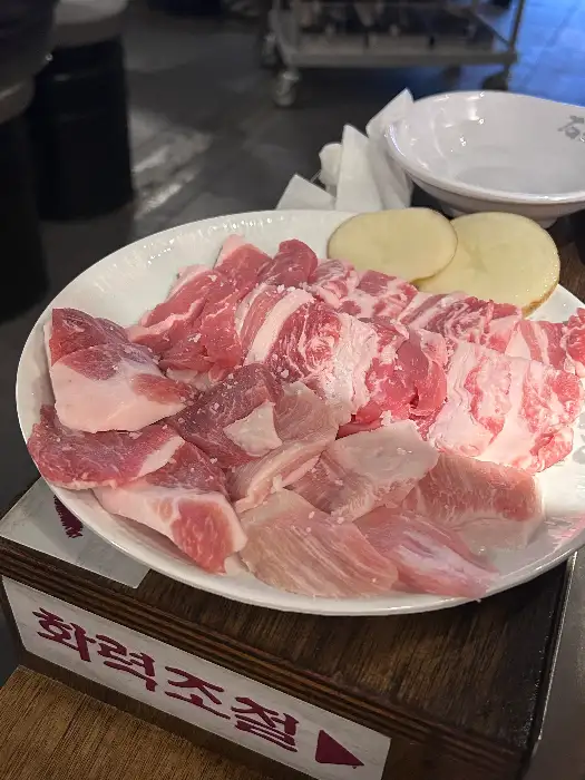 두툼하게 썰린 삼겹살과 곁들임 재료들