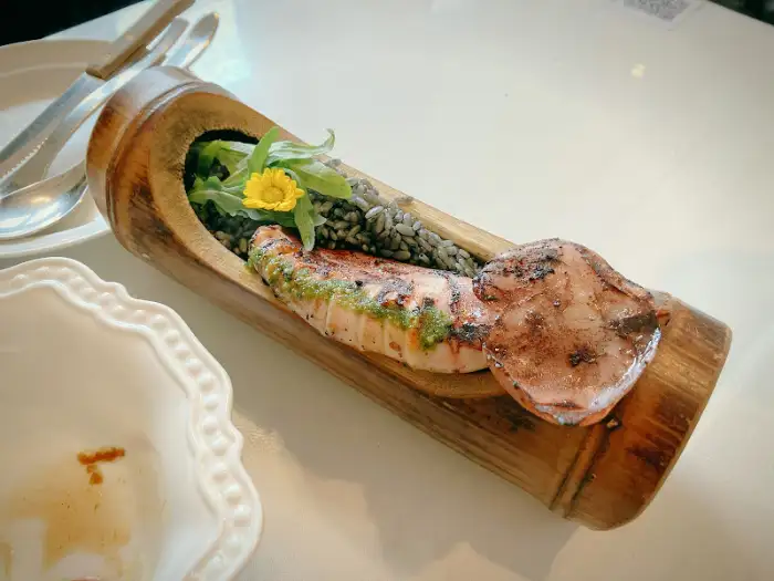 대나무 통에 담긴 먹물 리조또와 오징어 구이