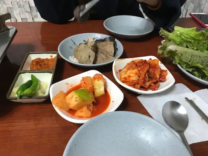테이블 위에 차려진 다양한 반찬과 쌈채소.