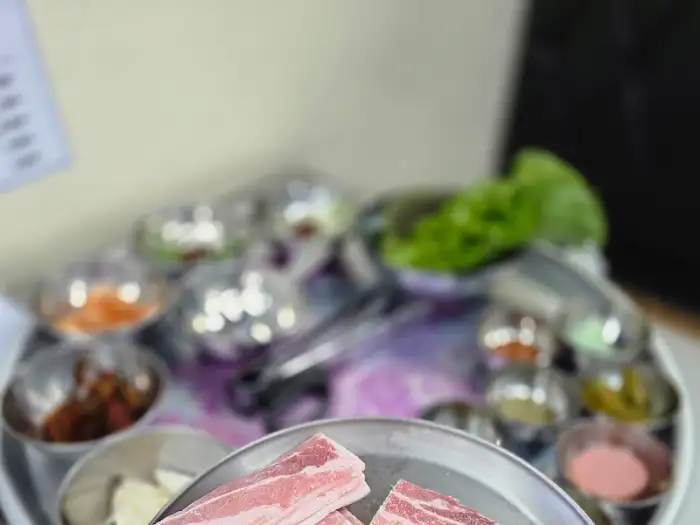 월드냉삼 삼봉지구점의 푸짐한 기본 상차림. 다양한 소스와 반찬들이 고기의 맛을 더합니다.
