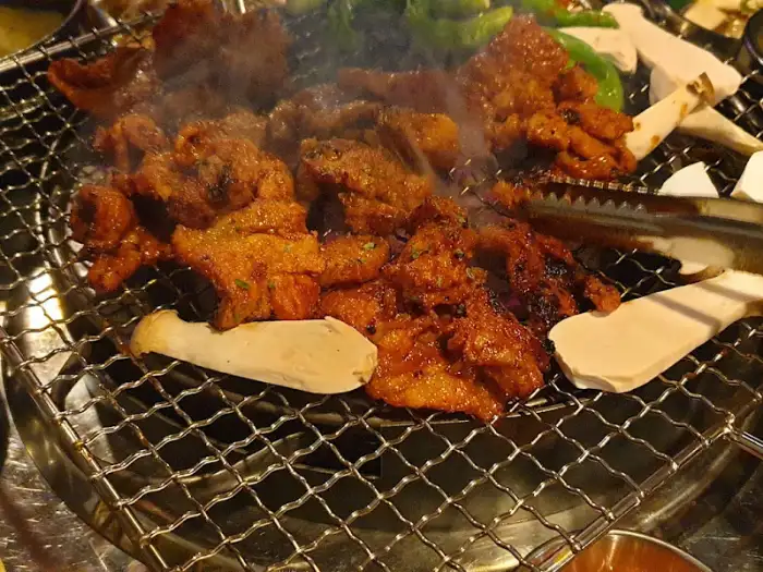불판 위에서 익어가는 양념된 고기