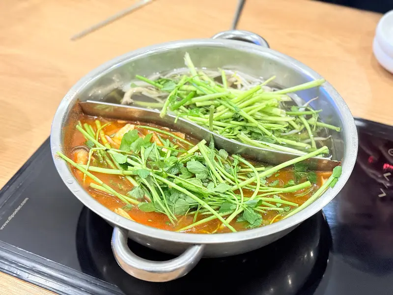 미나리와 채소가 가득한 샤브샤브 냄비