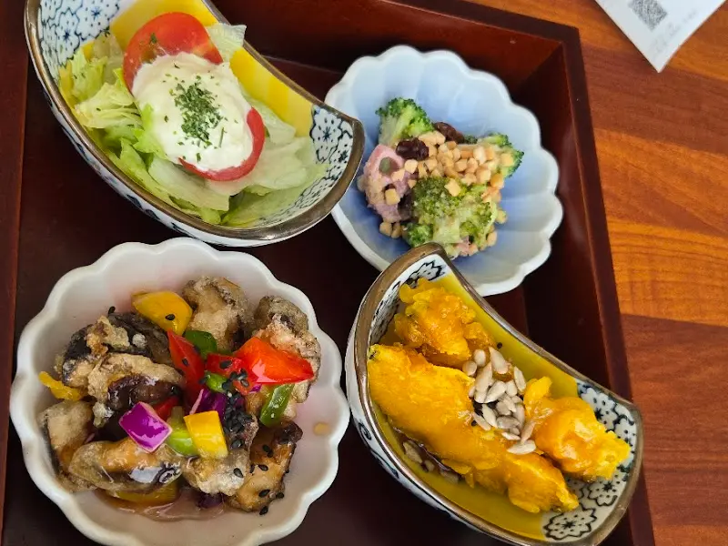 정갈하게 담긴 네 가지 반찬. 샐러드, 멸치볶음, 김치 등이 제공된다.