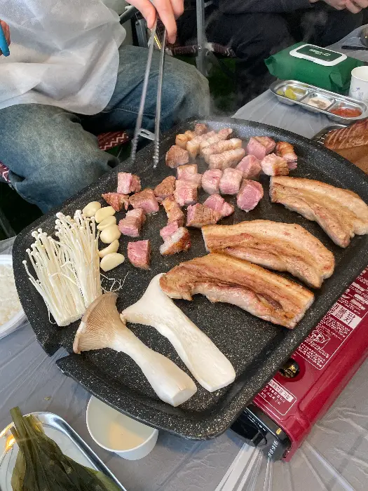 잘 구워지고 있는 고기와 버섯, 마늘
