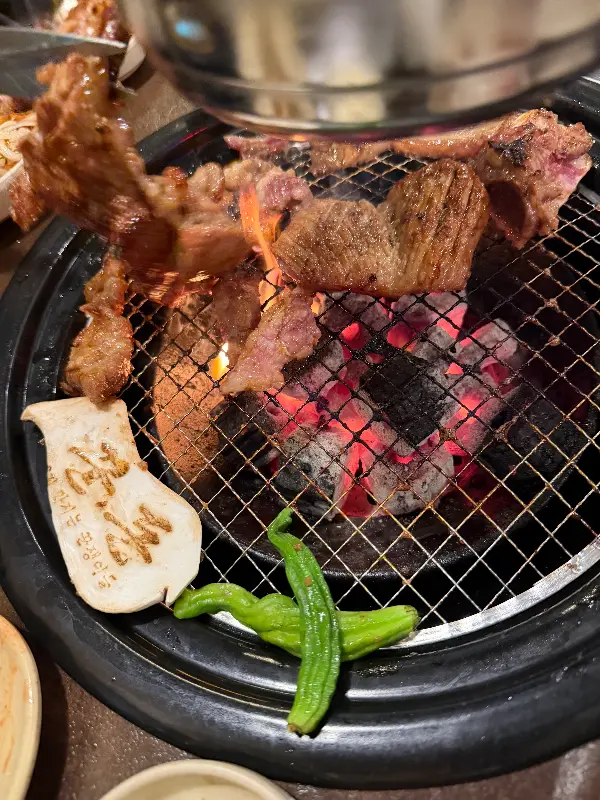 숯불 위에서 구워지는 돼지갈비와 버섯, 고추