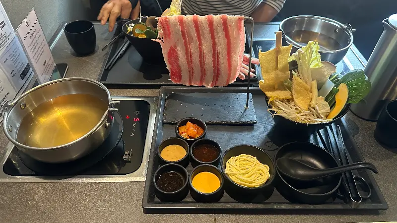 개인 트레이에 정갈하게 담긴 샤브샤브 재료와 소스