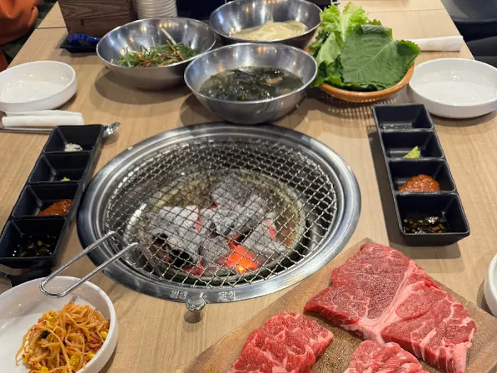 고기, 쌈채소, 김치, 그리고 여러 가지 반찬이 차려진 식탁