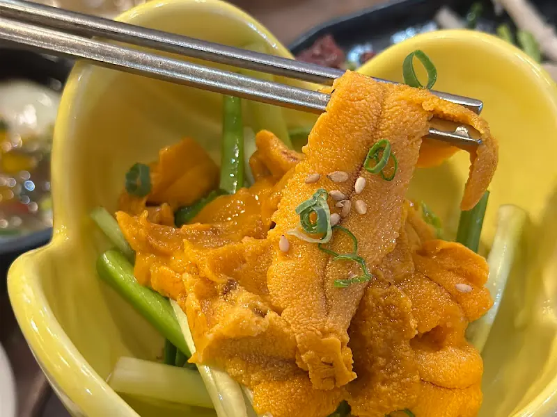 노란 성게알을 젓가락으로 집어 올린 모습