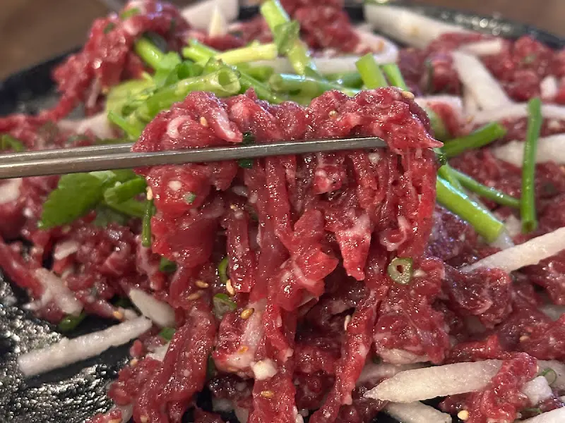 젓가락으로 육회를 들어올리는 모습