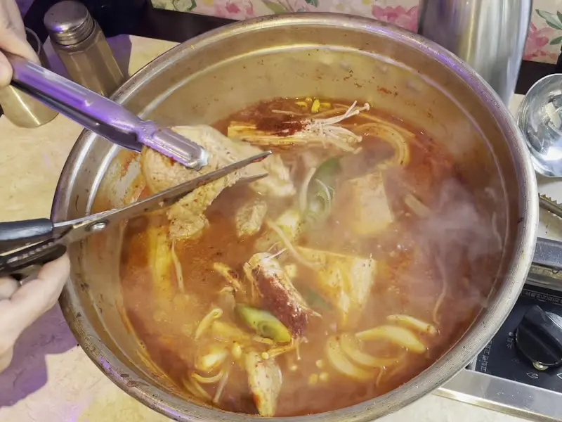 김치찌개에 들어간 돼지고기를 자르는 모습