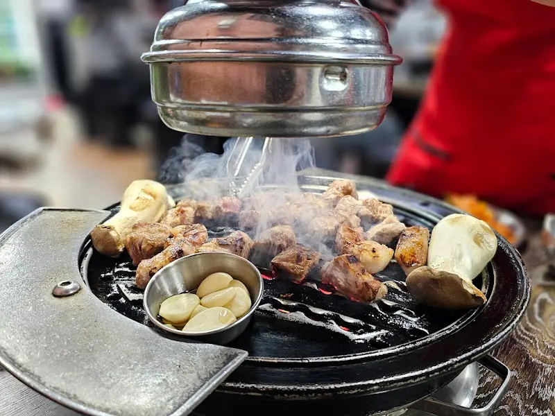 불판 위에서 연기를 내며 익어가는 돼지고기