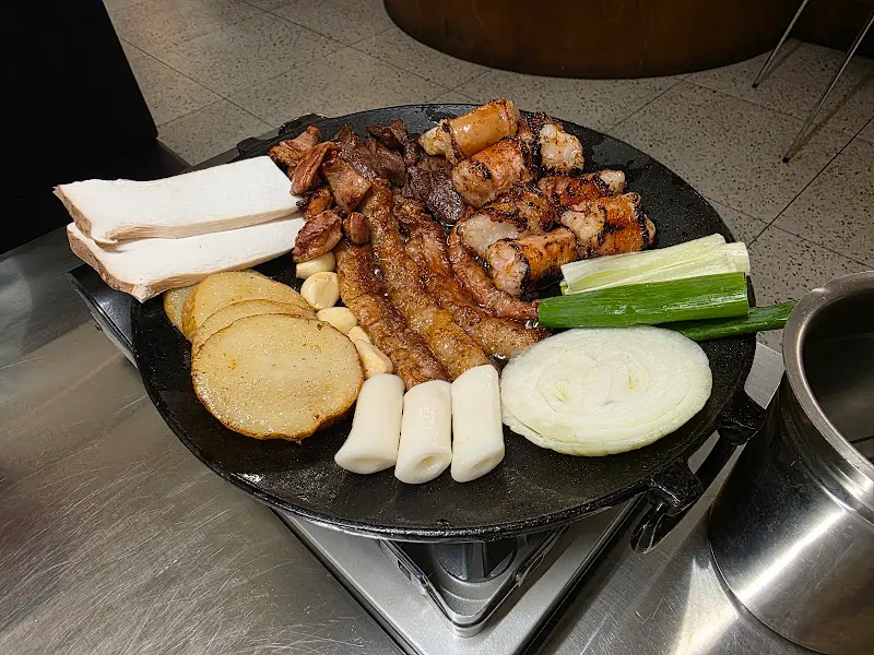 불판 위에 곱창과 곁들임 메뉴가 함께 구워지고 있는 모습