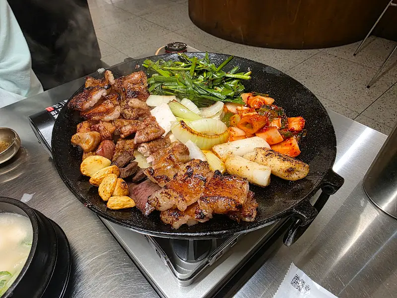 곱창, 대파김치, 부추 겉절이가 불판 위에 올려져 있는 모습